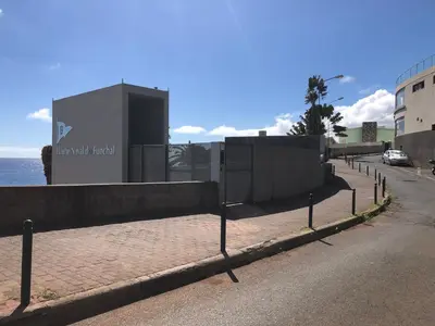 a street in front of a building next to the ocean at Beach Studio Apartment in Funchal