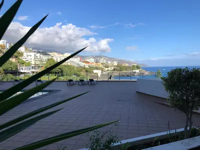 a patio with chairs and a view of the ocean at Beach Studio Apartment in Funchal