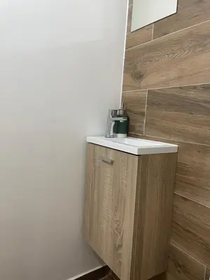 a bathroom with a sink and a wooden wall at Neves GuestLoft by Madeira Holiday Rentals in Ribeira Brava