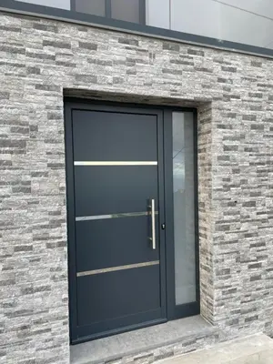 a black garage door on a brick building at Neves GuestLoft by Madeira Holiday Rentals in Ribeira Brava