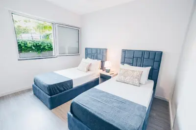 a bedroom with two beds and a window at Elephant by Wanderlust Madeira - 2BR Apartment with Terrace, side Sea View and pool access in Funchal