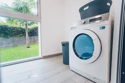 a washing machine in a room with a window at Elephant by Wanderlust Madeira - 2BR Apartment with Terrace, side Sea View and pool access in Funchal