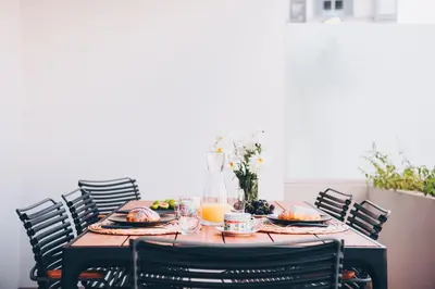 a table with plates of food and orange juice at Elephant by Wanderlust Madeira - 2BR Apartment with Terrace, side Sea View and pool access in Funchal