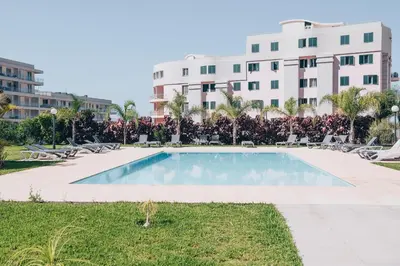 a swimming pool in front of a building at Elephant by Wanderlust Madeira - 2BR Apartment with Terrace, side Sea View and pool access in Funchal
