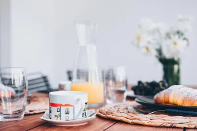 a table with a coffee cup and plates of food at Elephant by Wanderlust Madeira - 2BR Apartment with Terrace, side Sea View and pool access in Funchal