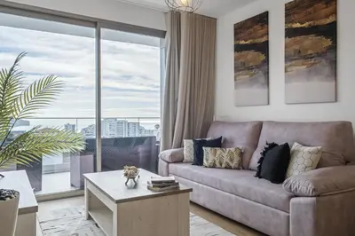 a living room with a couch and a large window at Inner City by Homie in Funchal