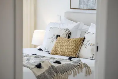 a bedroom with a white bed with pillows at Inner City by Homie in Funchal