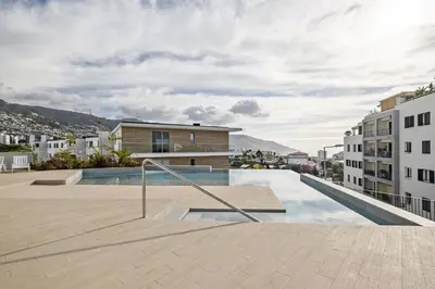 a swimming pool in the middle of a city with buildings at Inner City by Homie in Funchal