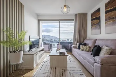 a living room with a couch and a large window at Inner City by Homie in Funchal