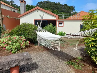 a hammock in a garden in front of a house at Peaceful place in Porto Moniz in Salão