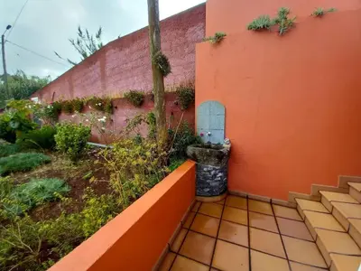 an orange wall with a small door on it at Peaceful place in Porto Moniz in Salão
