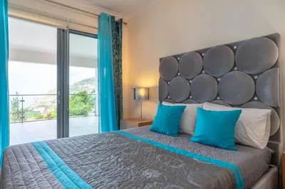 a bedroom with a large bed with a large window at Belo Mar in Arco da Calheta