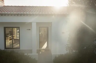 a white house with a red roof and two windows at Villa Beatriz Ocean View in Aljezur