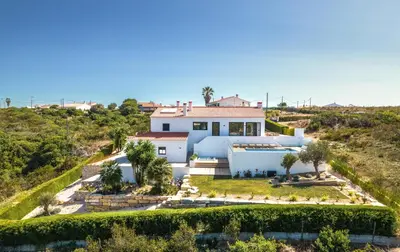 a white house with the sun shining on it at Villa Beatriz Ocean View in Aljezur