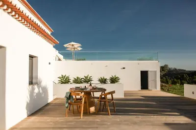a white bedroom with a bed with two lamps at Villa Beatriz Ocean View in Aljezur