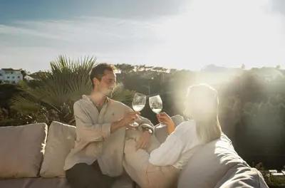 a man and woman sitting on a couch drinking wine at Villa Beatriz Ocean View in Aljezur