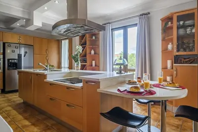 a kitchen with a island with a table and chairs at Central Lido Apartment by Homie in Funchal