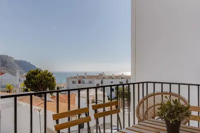 a balcony with a bench and a view of the ocean at Casa da Irene - A047 in Luz