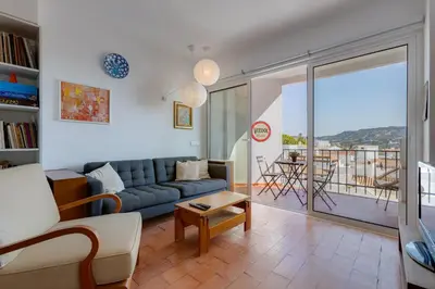 a living room with a blue couch and a balcony at Casa da Irene - A047 in Luz