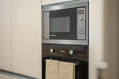 a microwave oven with a towel hanging from it at Sea View - 3 Pools - Parking - Gym - Supermarket - Prime Location in Funchal
