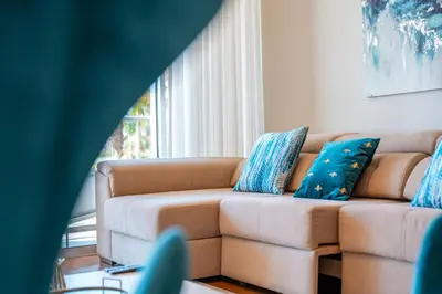 a living room with a couch with blue pillows at Sea View - 3 Pools - Parking - Gym - Supermarket - Prime Location in Funchal