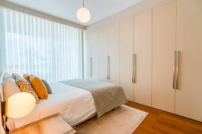 a bedroom with a bed and a large window at Sea View - 3 Pools - Parking - Gym - Supermarket - Prime Location in Funchal