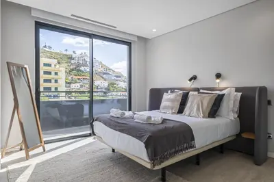 a bedroom with a bed and a large window at Tower Penthouse by Homie in Funchal