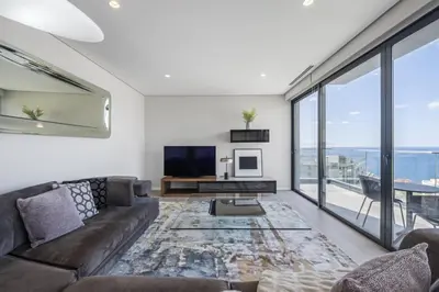 a living room with a couch and a tv and large windows at Tower Penthouse by Homie in Funchal