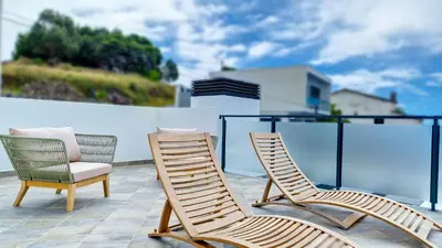 a couple of chairs sitting on a balcony at Ohana Ocean View by Lovelystay in Arco da Calheta