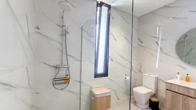 a bathroom with a glass shower and a toilet at Ohana Ocean View by Lovelystay in Arco da Calheta