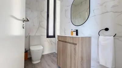 a bathroom with a sink and a toilet and a mirror at Ohana Ocean View by Lovelystay in Arco da Calheta