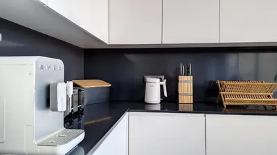 a kitchen with white cabinets and a coffee maker at Ohana Ocean View by Lovelystay in Arco da Calheta