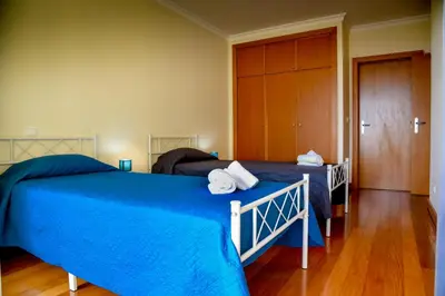 a bedroom with two beds and a closet at Green Pearl Apartment in Funchal