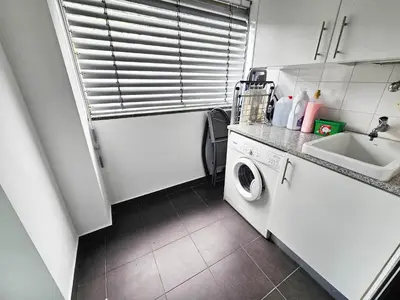 a small kitchen with a washing machine and a sink at Machico Oasis - Mountainview in Machico