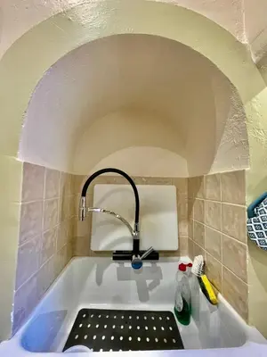 a bath tub with a faucet in a bathroom at Quartos privados - Quinta da Paz in Santa Cruz
