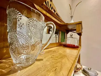 a glass pitcher sitting on top of a wooden table at Quartos privados - Quinta da Paz in Santa Cruz