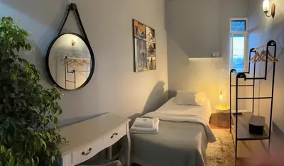 a small room with a bed and a mirror at Funchal 19 in Funchal