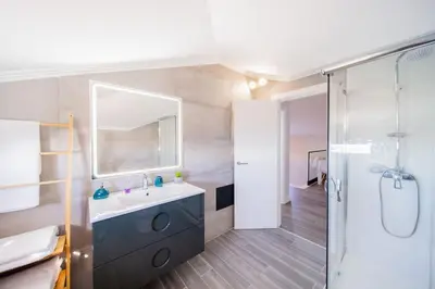 a bathroom with a sink and a mirror and a shower at Pena View Apartment in Santa Cruz