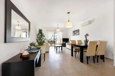 a dining room and living room with a table and chairs at Chez Hélène et Paulo - Lagos in Lagos