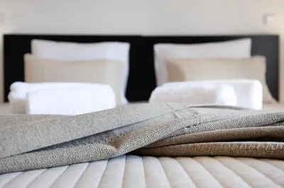 a pile of towels sitting on top of a bed at Chez Hélène et Paulo - Lagos in Lagos