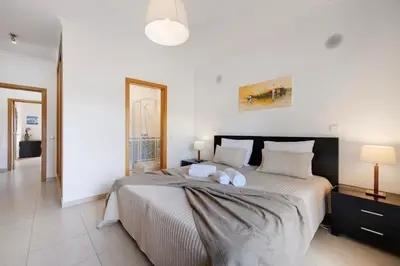a bedroom with a large bed with two towels on it at Chez Hélène et Paulo - Lagos in Lagos