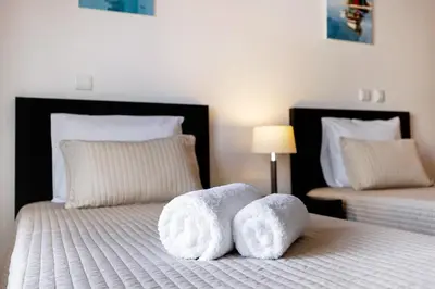 a bedroom with two beds with white towels on them at Chez Hélène et Paulo - Lagos in Lagos
