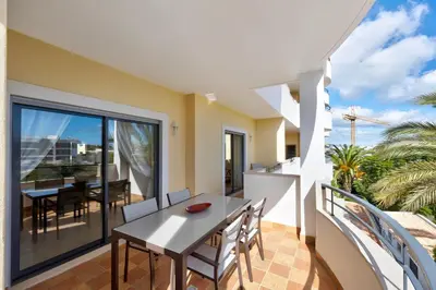 a dining room with a table and chairs on a balcony at Chez Hélène et Paulo - Lagos in Lagos