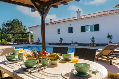 a table with food and drinks on it next to a pool at Casa Sol a Sol - Villa with Swimming Pool by Lisbeyond in Aljezur