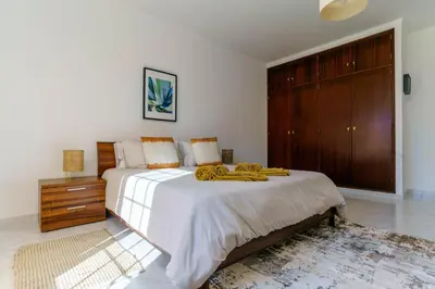 a bedroom with a large bed with yellow towels on it at Casa Sol a Sol - Villa with Swimming Pool by Lisbeyond in Aljezur