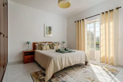 a white bedroom with a bed and a window at Casa Sol a Sol - Villa with Swimming Pool by Lisbeyond in Aljezur