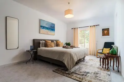 a bedroom with a large bed and a table at Casa Sol a Sol - Villa with Swimming Pool by Lisbeyond in Aljezur