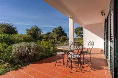 a patio with a table and chairs on a balcony at Casa Sol a Sol - Villa with Swimming Pool by Lisbeyond in Aljezur