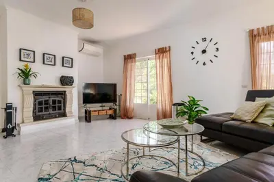 a living room with a couch and a clock on the wall at Casa Sol a Sol - Villa with Swimming Pool by Lisbeyond in Aljezur