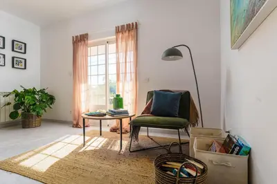 a living room with a chair and a table and a window at Casa Sol a Sol - Villa with Swimming Pool by Lisbeyond in Aljezur